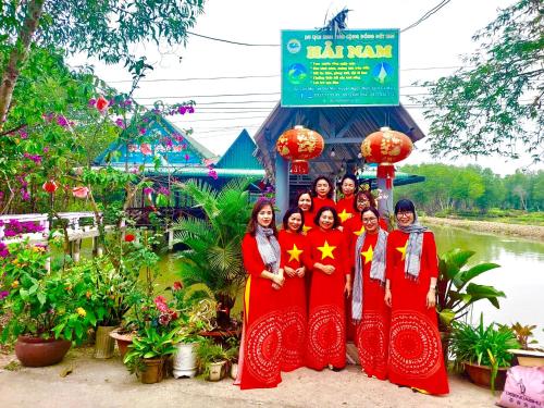 a group of women posing for a picture in front of a building at Homestay Hải Nam Đất Mũi in Xóm Mũi