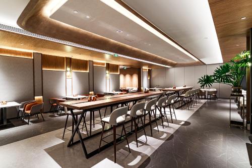 南京市にあるUrCove by HYATT Nanjing South Railway Stationの長いテーブルと椅子のあるダイニングルーム