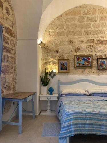 ein Schlafzimmer mit einem Bett und einer Steinmauer in der Unterkunft Casa Bandini in Galatone
