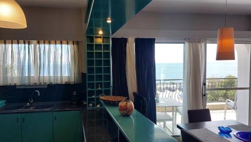 a kitchen with green cabinets and a view of the ocean at Vicky's place in Artemida