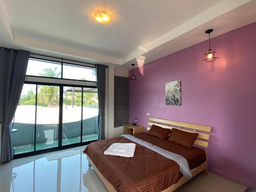 a purple bedroom with a bed and a large window at Cordelia Resort Sam Roi Yot in Sam Roi Yot