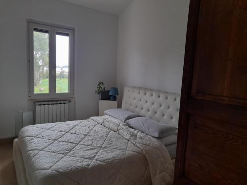 Un dormitorio con una cama grande y una ventana en casa nel bosco, en Bella Farnia