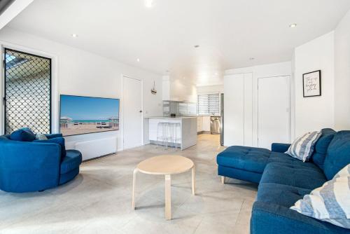 a living room with a blue couch and a table at Palm Beach Haven in Gold Coast