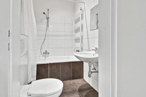 een witte badkamer met een toilet en een wastafel bij 3-room apartment in Bochum