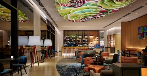 a lobby with a restaurant with a flower ceiling at Amari Kuala Lumpur in Kuala Lumpur