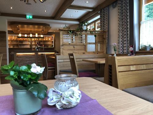 a dining room with a table with a vase of flowers at Gasthof Botenwirt in Faistenau