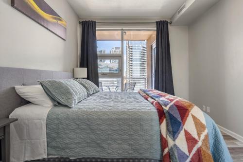 a bedroom with a bed and a window with a view at City View 1BR Downtown Calgary in Calgary