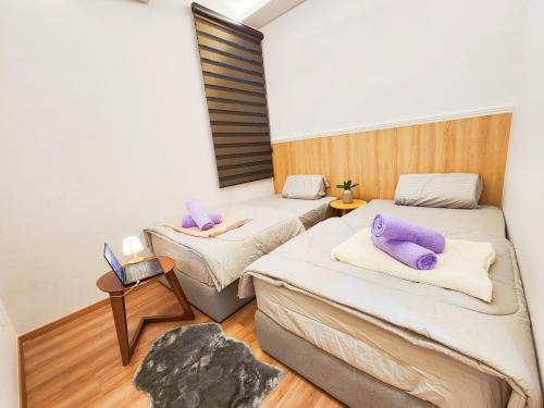 Cette chambre comprend 2 lits avec des oreillers violets. dans l'établissement The Cove Ipoh Fully Air-Con Garden East, Taman Ipoh Permai, 31400 Ipoh, Perak,, à Ipoh