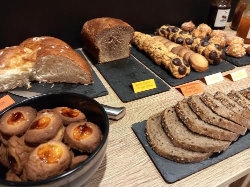 a table with different types of bread and pastries at Intense Boutik-Hôtel in Port-Vendres