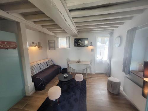 a living room with a couch and a table at Domaine "Les Bois Flottes" dans Maison de Charme au bord de mer et proche de Cabourg in Merville-Franceville-Plage