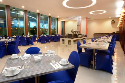 un comedor con sillas y mesas azules en Sahid Azizah Syariah Hotel and Convention Kendari en Lepoleop