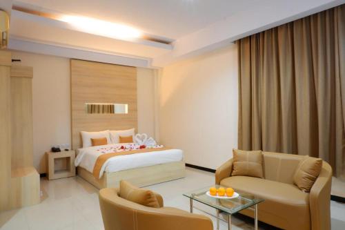 a hotel room with a bed and a living room at Sahid Azizah Syariah Hotel and Convention Kendari in Lepoleop