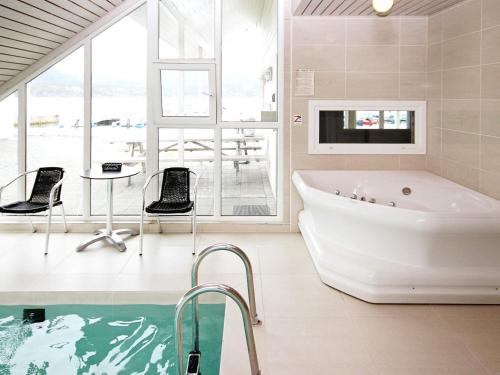 La salle de bains est pourvue d'une baignoire, d'une télévision et de chaises. dans l'établissement Five-Bedroom Holiday home in Jelsa 2, à Jelsa