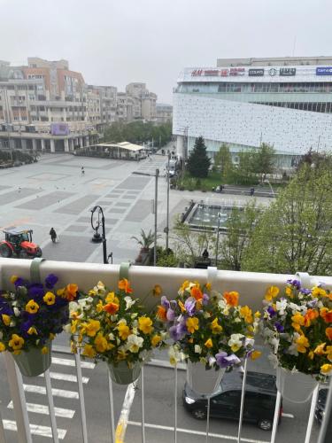 a bunch of flowers on a balcony with a city at Sweet cozy Ultracentral in Craiova