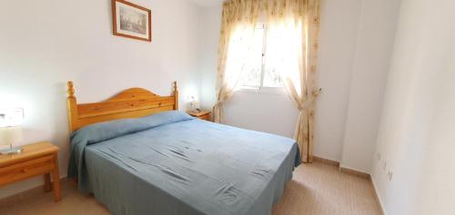 ein Schlafzimmer mit einem blauen Bett und einem Fenster in der Unterkunft DALI VAC004 Denirent in Denia