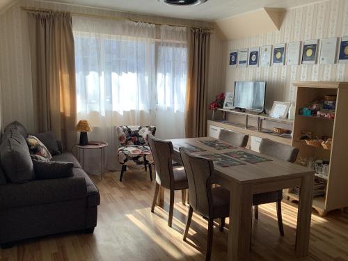 a living room with a table and chairs and a couch at Lana House in Pärnu