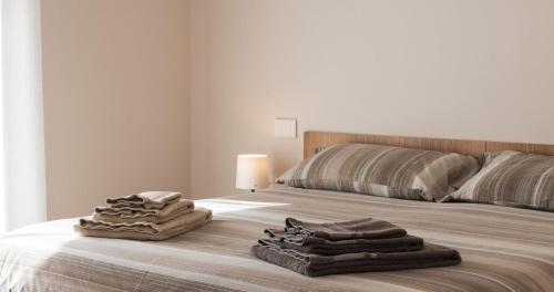 a bedroom with a bed with towels on it at Appartamenti Del Borgo in Borgosesia