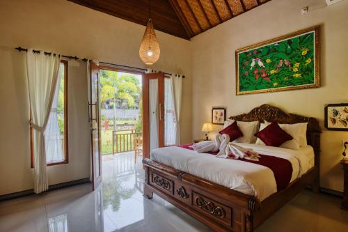 a bedroom with a large bed and a large window at Tegal Besung Cottage in Nusa Penida