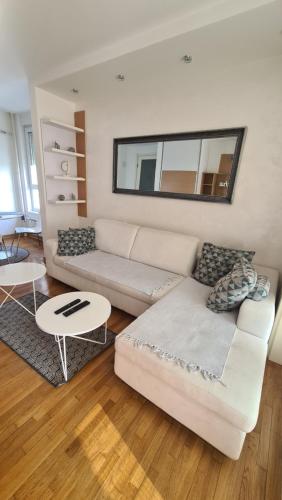 Belville City apartment في بلغراد: غرفة معيشة مع أريكة بيضاء وطاولة