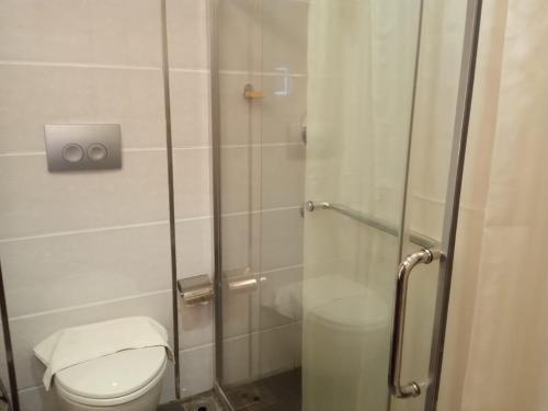 e bagno con servizi igienici e doccia in vetro. di Vakkom Palazzo a Varkala