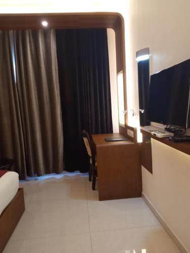a hotel room with a desk and a computer in a room at Vakkom Palazzo in Varkala