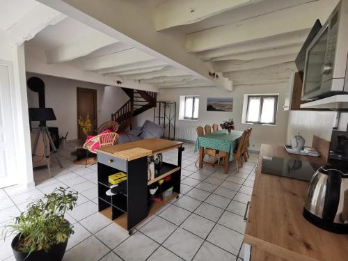 een keuken en een woonkamer met een tafel en stoelen bij Equinoxe in Dragey