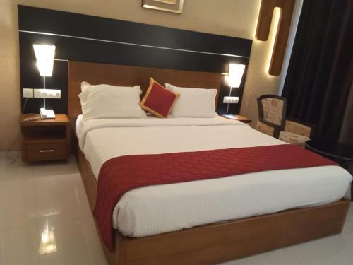 un grande letto in una camera d'albergo con due lampade di Vakkom Palazzo a Varkala