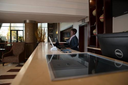a woman standing at a counter in an office at The RidgePoint Hotel in Witbank