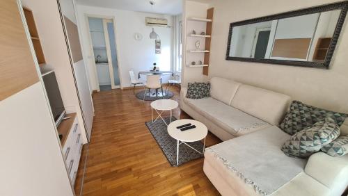 Belville City apartment في بلغراد: غرفة معيشة مع أريكة وطاولة