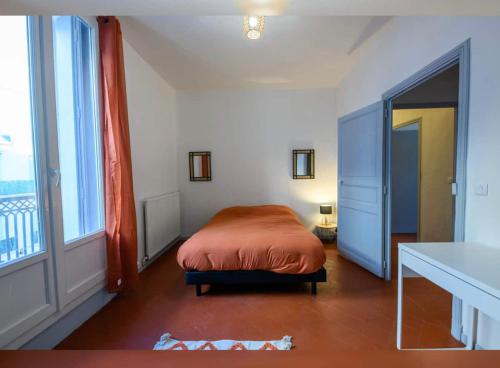 a bedroom with a bed and a large window at Grand appartement de 100M2 -Allée Paul Riquet Béziers - 4chambres - Wifi- Tv connectée in Béziers