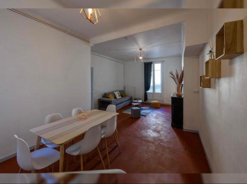 a living room with a table and white chairs at Grand appartement de 100M2 -Allée Paul Riquet Béziers - 4chambres - Wifi- Tv connectée in Béziers