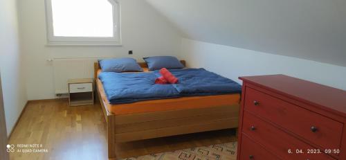 een slaapkamer met een bed met blauwe lakens en een rood kussen bij Pocitniska hisa Frida in Rogaška Slatina