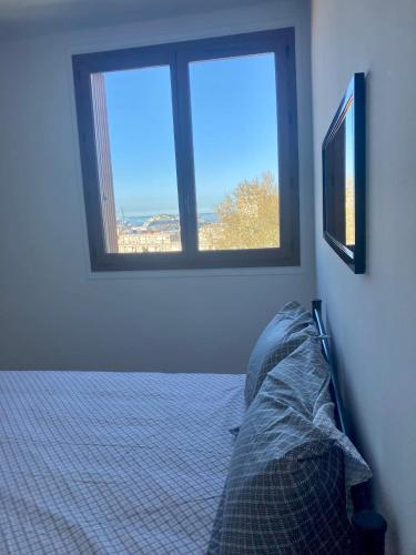 un salon avec un canapé et une fenêtre dans l'établissement Escapade phocéenne, à Marseille