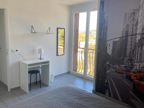 - une chambre avec un bureau et une vue sur la ville dans l'établissement Escapade phocéenne, à Marseille