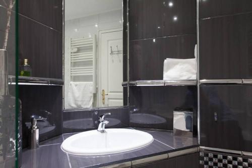 une salle de bain avec un lavabo blanc et un miroir dans l'établissement Cannes Meynadier: Superbe appartement trois pièces, à Cannes