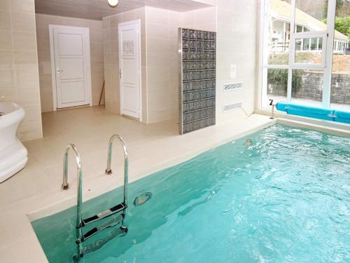 a bathroom with a large swimming pool with a tub at Holiday Home Foreneset in Jelsa