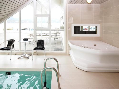 a bathroom with a tub and a tv and a pool at Holiday Home Foreneset in Jelsa
