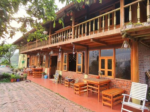a building with wooden tables and chairs on a patio at La Beauté Sa Pa in Sa Pa