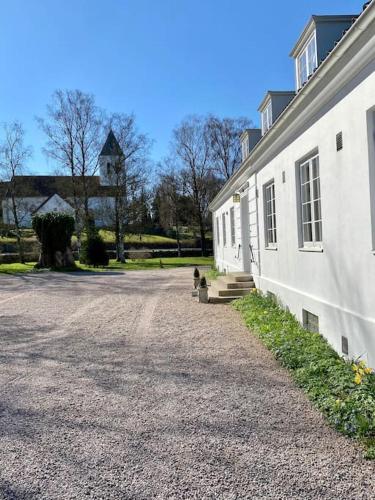 a dog sitting next to a building with a clock tower at Prästgårdsidyll Gästhus med Boutique-känsla in Sösdala