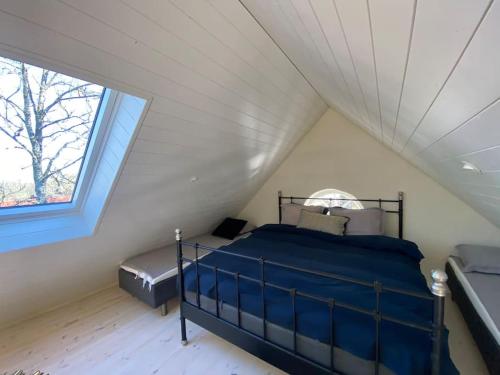 a bedroom with a bed and a window in a attic at Exklusivt gästhus på anrik prästgård in Sösdala
