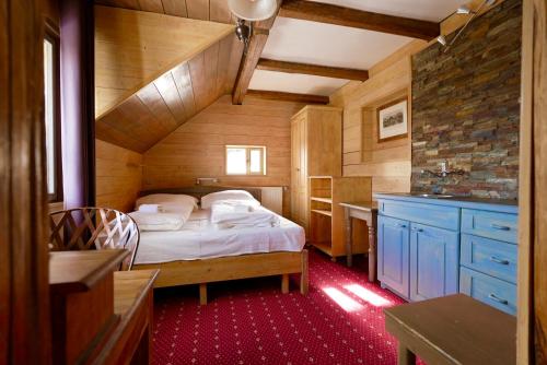 una camera da letto con letto in una camera in legno di Penzion U Kotle a Horní Mísečky