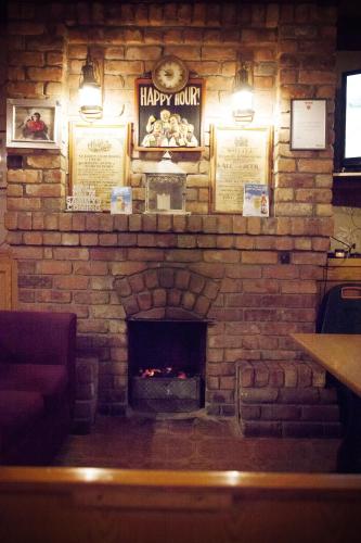 a brick wall with a fireplace in a restaurant at The Derg Arms B&B in Castlederg