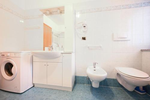 ein Badezimmer mit einem Waschbecken und einer Waschmaschine in der Unterkunft Majon Fior de Bosch 1 in Campitello di Fassa