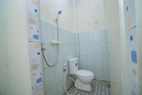 een badkamer met een toilet en een douche. bij RedDoorz Syariah near Rembele Airport Bener Meriah in Tingkeum