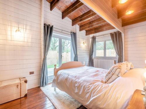 a bedroom with a large bed and a window at Little Yew Tree Lodge in Hambledon