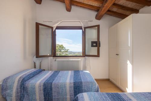 a bedroom with a bed and a large window at Country House La Meria in Catabbio