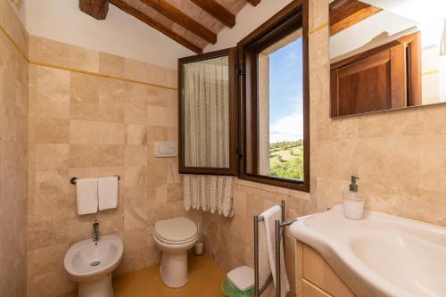 a bathroom with a sink toilet and a window at Country House La Meria in Catabbio