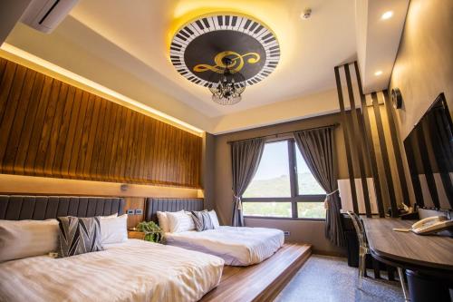a hotel room with two beds and a desk at Piano Hotel in Xiaoliuqiu