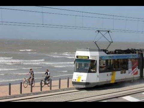 um comboio e duas pessoas em bicicletas e um eléctrico em Caravan Aan Zee Arnani em Middelkerke