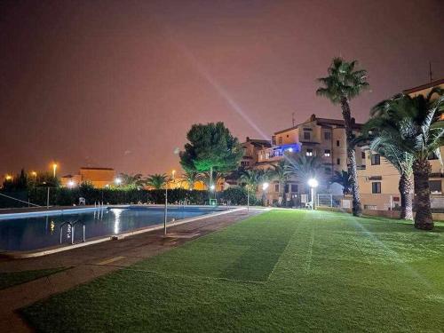ein Park mit Schwimmbad in der Nacht in der Unterkunft Apartamento ESTRELLA con vistas a la piscina in Torrevieja